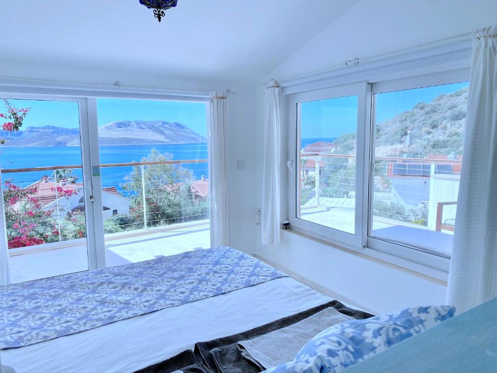 a bedroom with a bed and views of the ocean at Akdeniz Villa in Kas