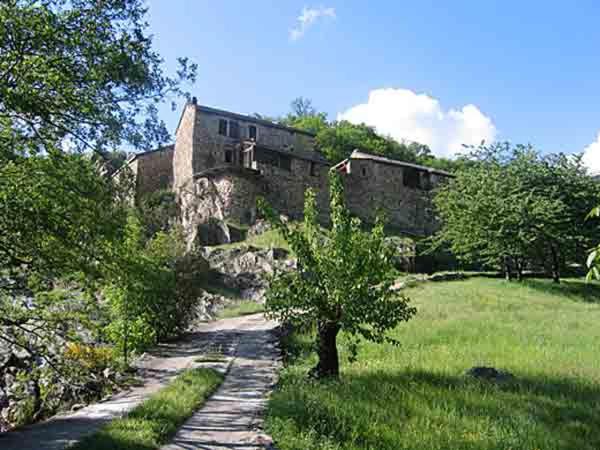 un bâtiment sur une colline avec un arbre dans un champ dans l'établissement MOULIN DELEUZE Chambre Le Chalet avec terrasse, à Beaumont