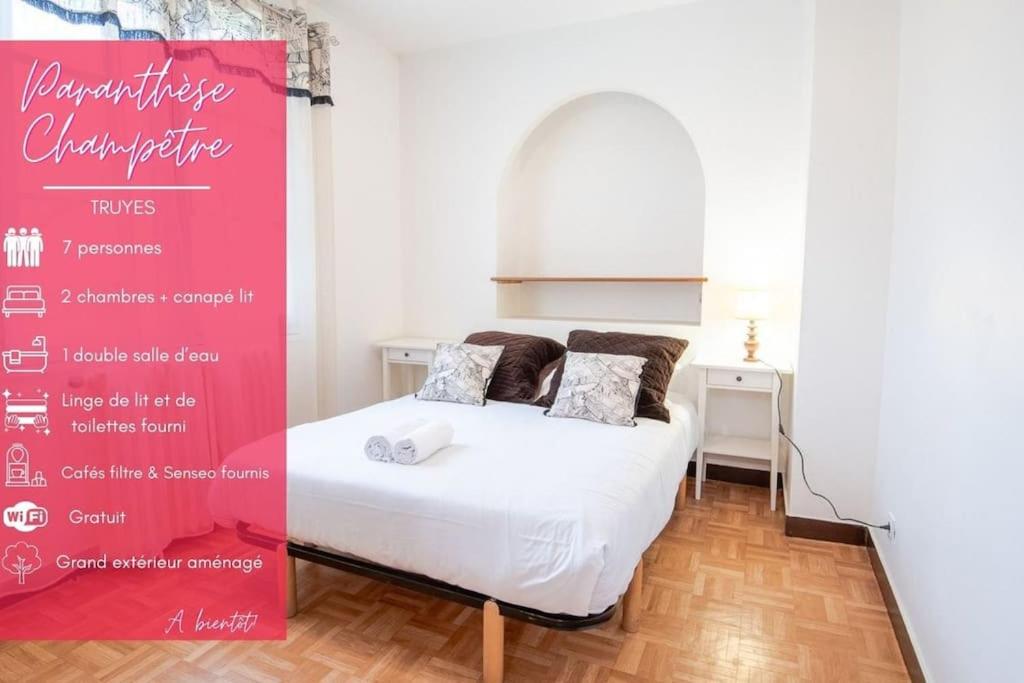 um quarto com uma cama branca e um sinal vermelho em Parenthèse champêtre : Maison 7 pers. em Truyes