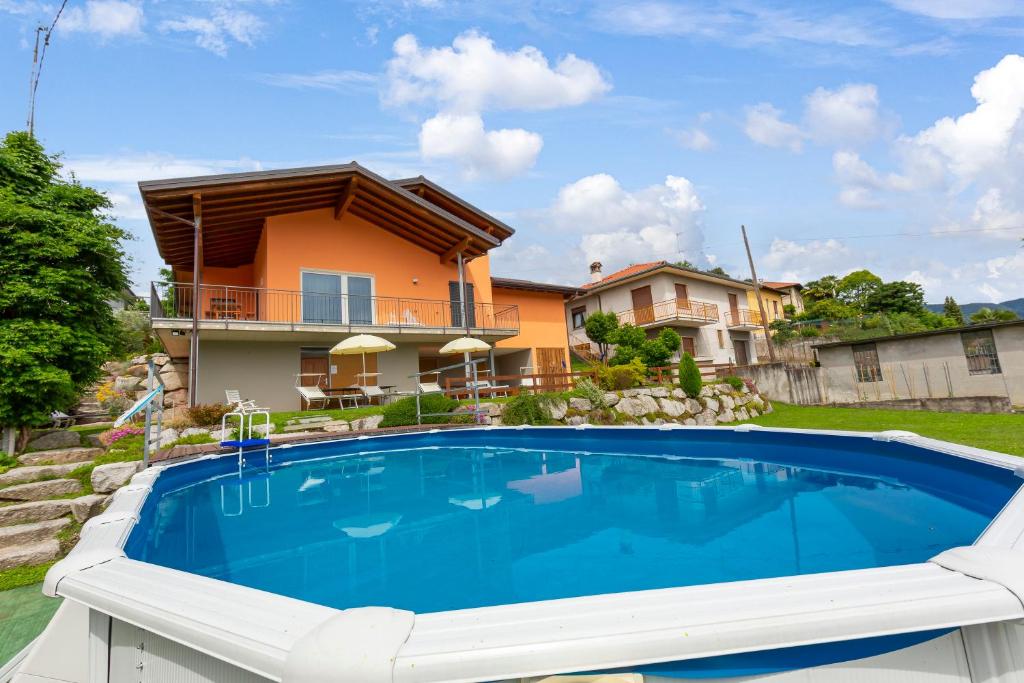 ein Haus mit einem großen Pool vor einem Haus in der Unterkunft Villa Laura Private Pool and Garden in Besozzo