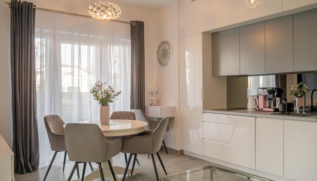 a kitchen and dining room with a table and chairs at Apartament MEWA SurfingBird Kołobrzeg in Kołobrzeg