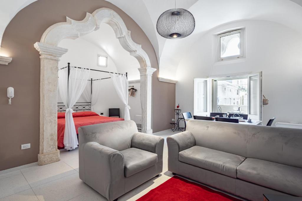 ナルドにあるLa Torretta - Nardò Charming Apartmentのベッドとソファと椅子のある寝室