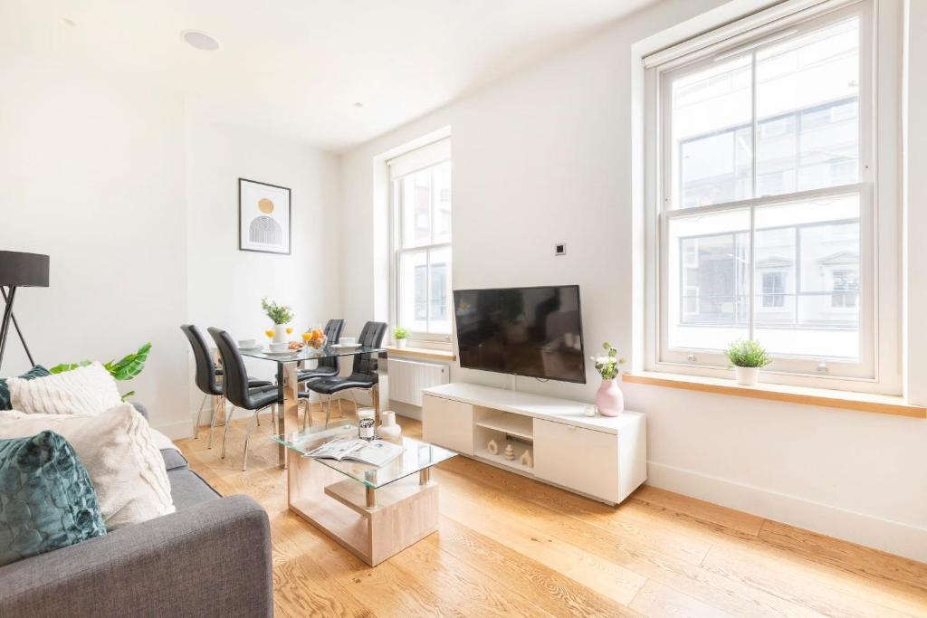 un soggiorno con divano e tavolo di Central London Soho Suite - CityApartmentStay a Londra