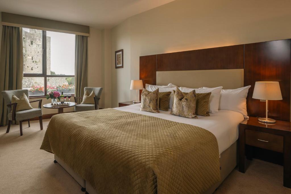Una habitación de hotel con una cama grande y una ventana. en Trim Castle Hotel, en Trim