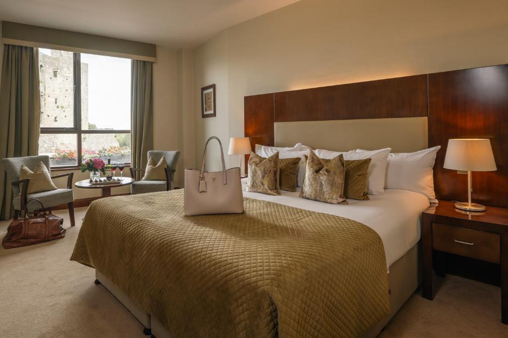 una habitación de hotel con una cama grande con una bolsa. en Trim Castle Hotel, en Trim