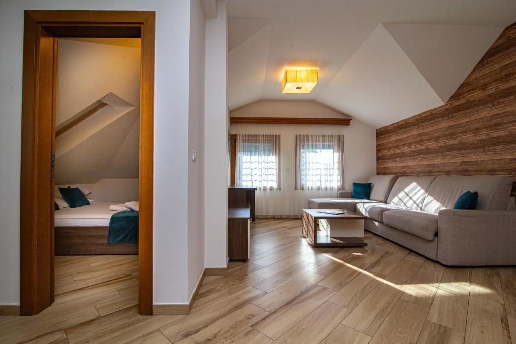 a living room with a couch and a bed at Central Inn in Zlatibor