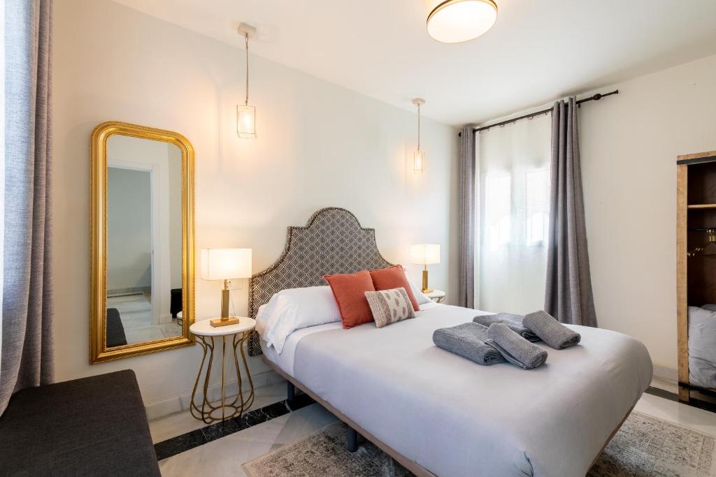 a bedroom with a large bed and a mirror at Arco de la Seda - Hotel Boutique in Seville