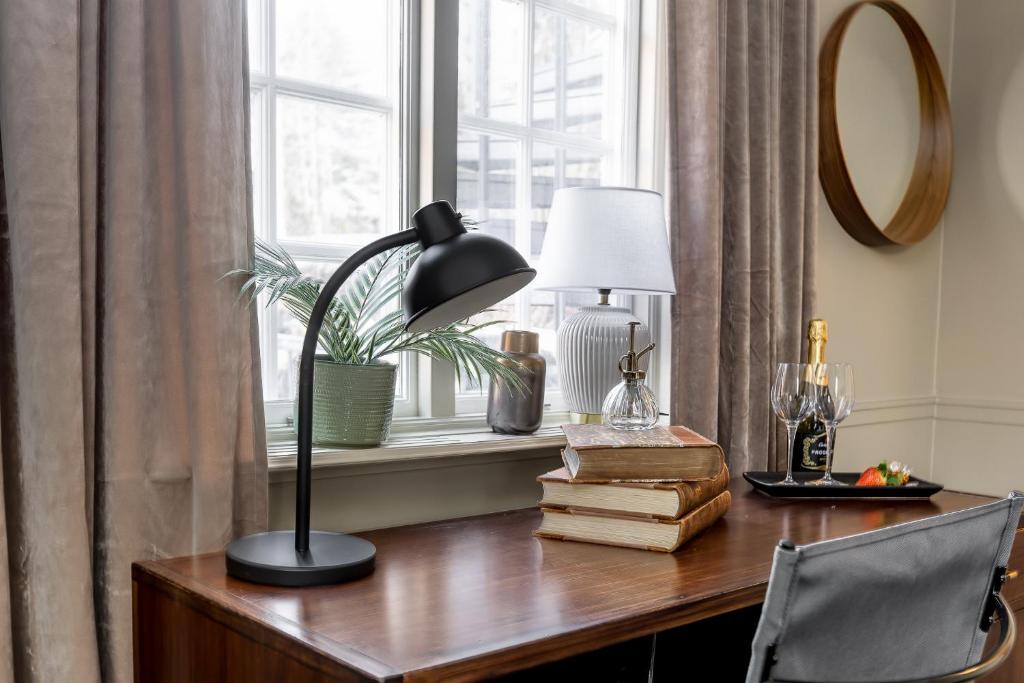 a desk with a lamp and a window at Brunnsvik Hotell & Konferens in Ludvika