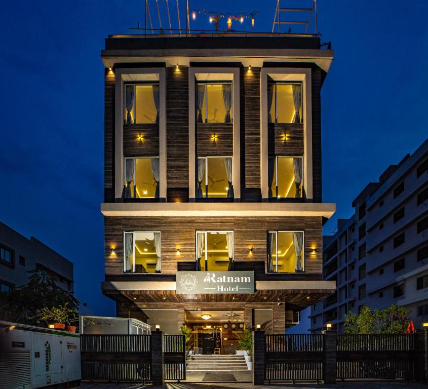 un edificio de apartamentos con una fachada iluminada por la noche en RABBIT RATNAM -By Udaipur Hotels, en Udaipur