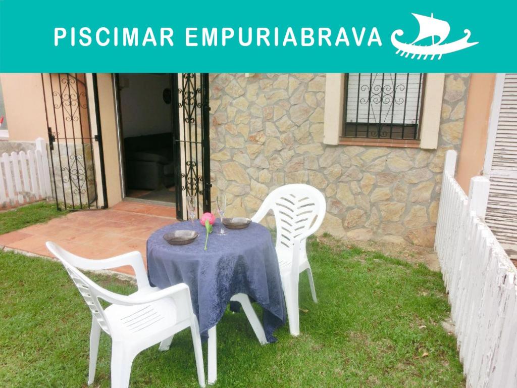 エンプリアブラバにあるEmpuriaapparts Piscimarの白い椅子と青いテーブルクロス