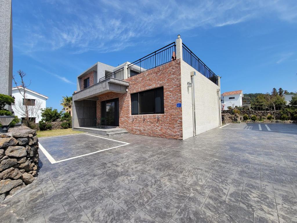 an empty parking lot in front of a brick building at Stay by J in Jeju