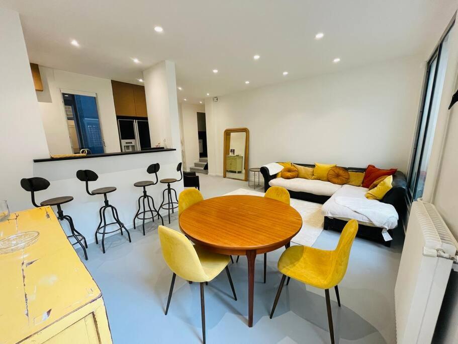 - un salon avec une table en bois et des chaises jaunes dans l'établissement Appartement 6 pièces / 5 chambres / calme / RDC, à Paris