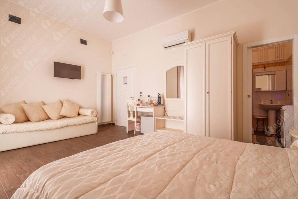 カノーザ・ディ・プーリアにあるDomuS al Corso con servizio B&Bの白いベッドルーム(ベッド1台、ソファ付)