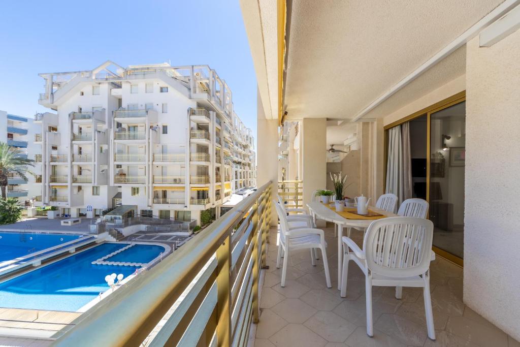 een balkon met een tafel en stoelen en een zwembad bij Apartamentos Novelty Arysal in Salou