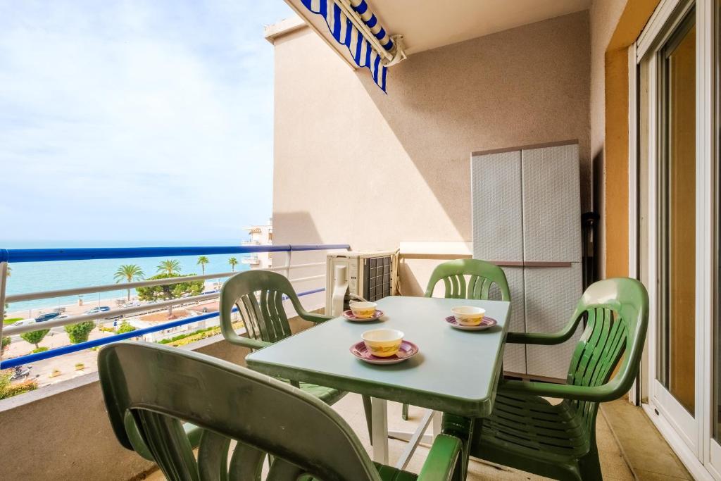 a table and chairs on a balcony with a view of the beach at Appartement au cros de cagnes bo001 in Cagnes-sur-Mer