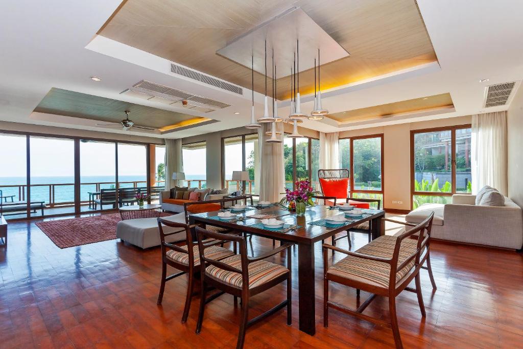 a living room with a dining table and chairs at ShaSa Resort - Luxury Beachfront Suites in Lamai