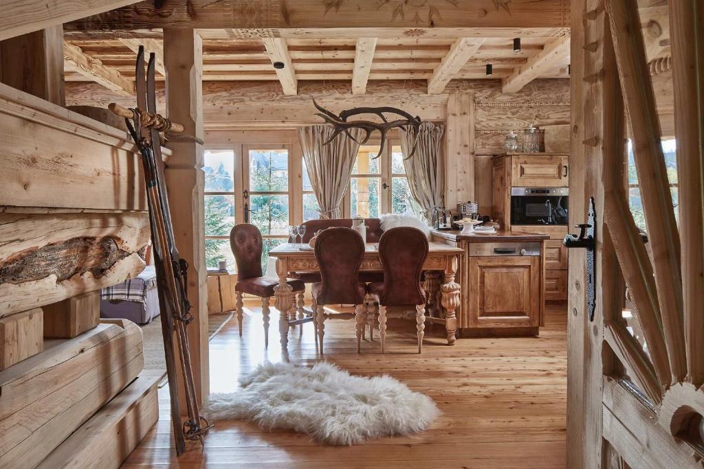 a dining room with a table and chairs in a cabin at GORSKA OSADA Luxury Chalets Zakopane in Poronin