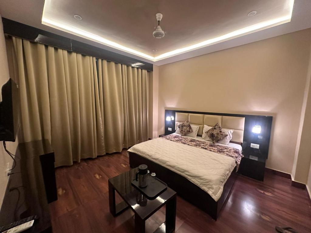 ein Schlafzimmer mit einem großen Bett und einem Tisch in der Unterkunft HOTEL KANAL KOTA in Kota