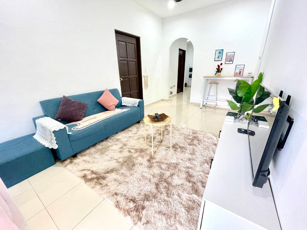 a living room with a blue couch and a table at Cozy 288 Entire 3 bedroom House @ Alma Bukit Mertajam in Bukit Mertajam