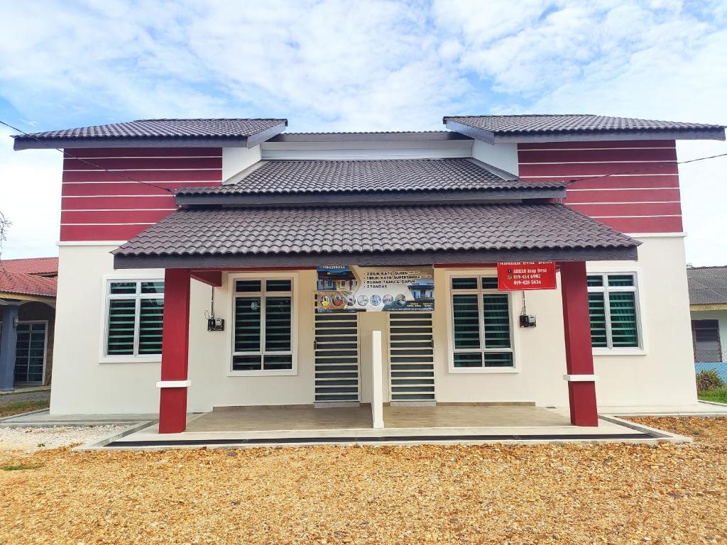 a small house with a red and white building at ABHAR Inap Desa in Alor Setar