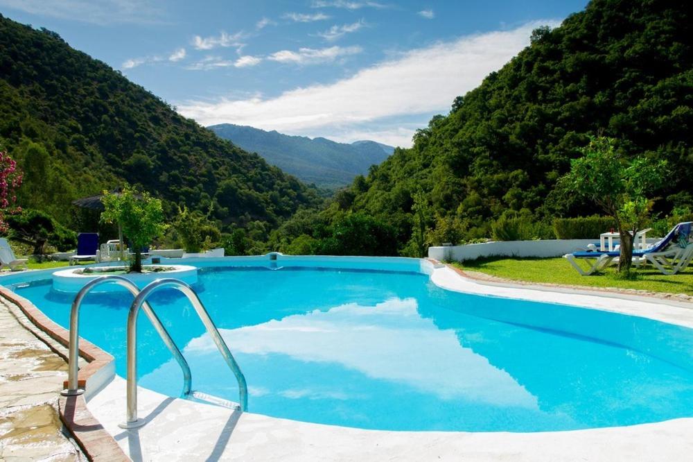 uma piscina azul com montanhas ao fundo em Finca El Huertezuelo em El Bosque