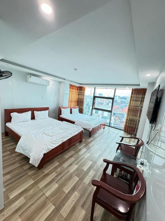 a bedroom with two beds and a television in it at Nhà nghỉ Thành Đạt in Hai Phong