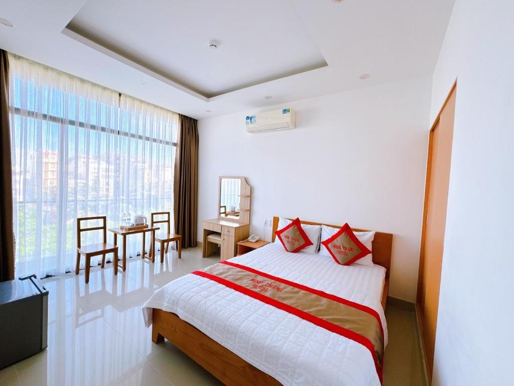 a bedroom with a bed and a table and a window at Hotel Minh Thắng in Vung Tau