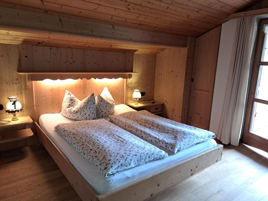 a bedroom with a large bed with two lamps on it at Haus Sunnleitn Vogelsang in Bayrischzell