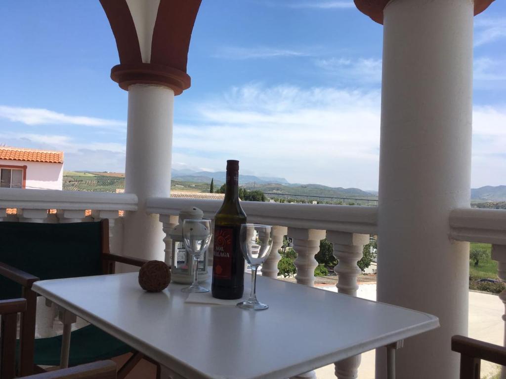 Una botella de vino sentada en una mesa en un balcón en Casa Carrión Caminito del Rey, en Bermejo