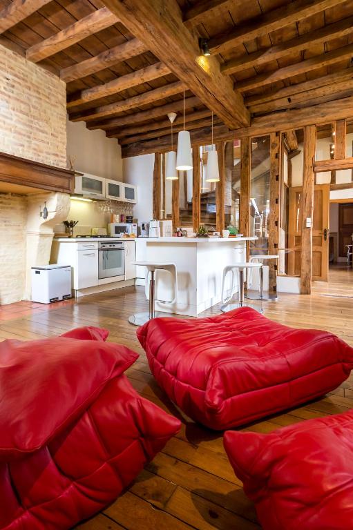 - un grand salon avec des poufs rouges au sol dans l'établissement Suite Mana OHANA - Luxe et Authenticité à 2 pas de la Place Ducale avec Parking privé, à Charleville-Mézières