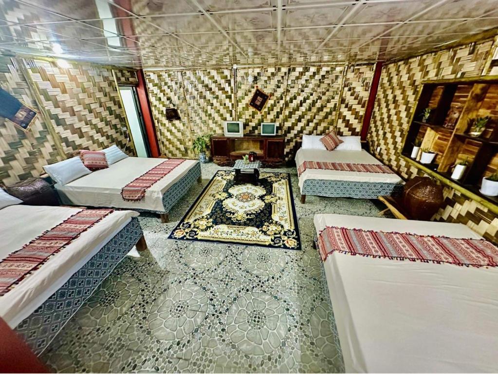 una camera con tre letti e un tavolo di Homestay Minh Ngọc a Ban Hin Lom