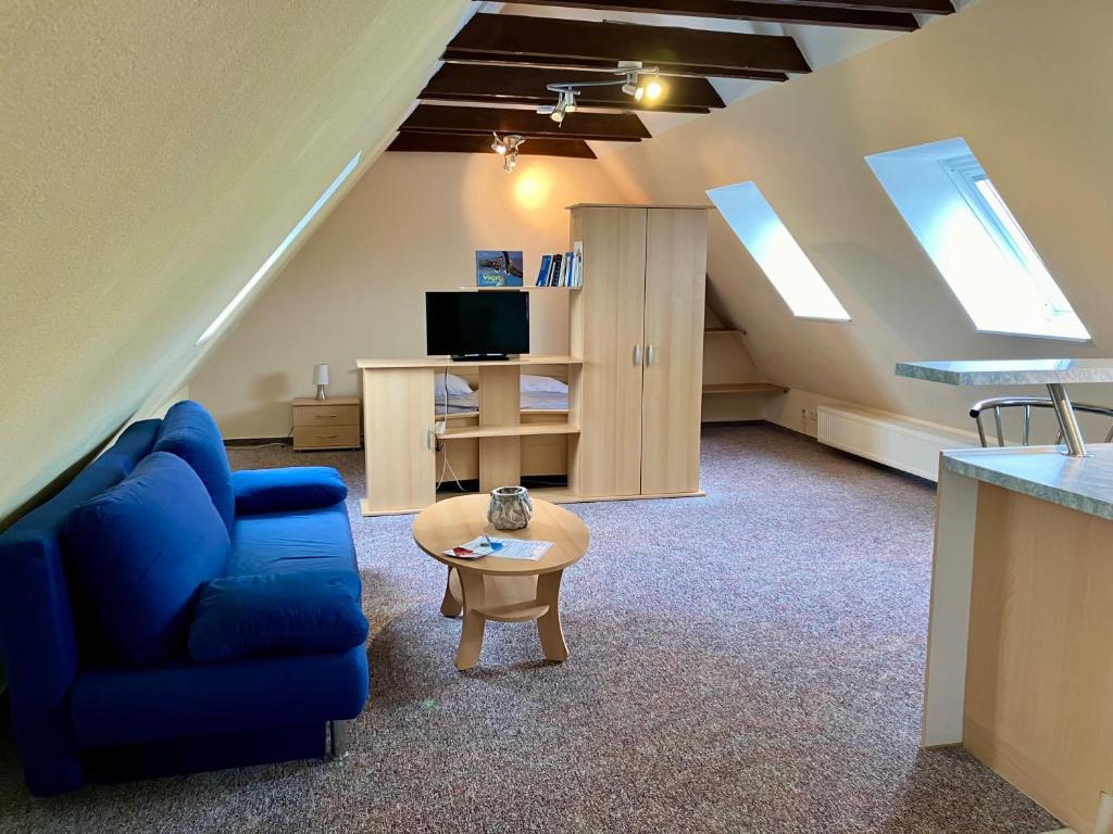 a living room with a blue couch and a table at Gemütliche Ferienwohnungen in Friedland Ortsteil Cosa in Friedland