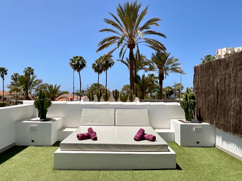 a white couch with pink shoes on it on a patio at Las Americas Luxury Low-Cost Apartment with Terrace & Views in Playa de las Americas