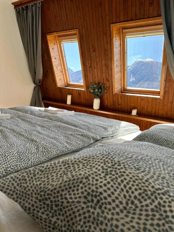 a bedroom with two beds and two windows at App Bovec in Bovec