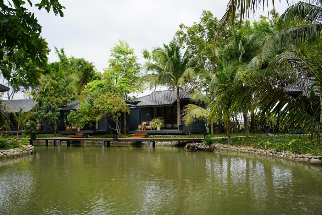 a house with a pond in front of it at Annhien home's in Ấp Long Thạnh