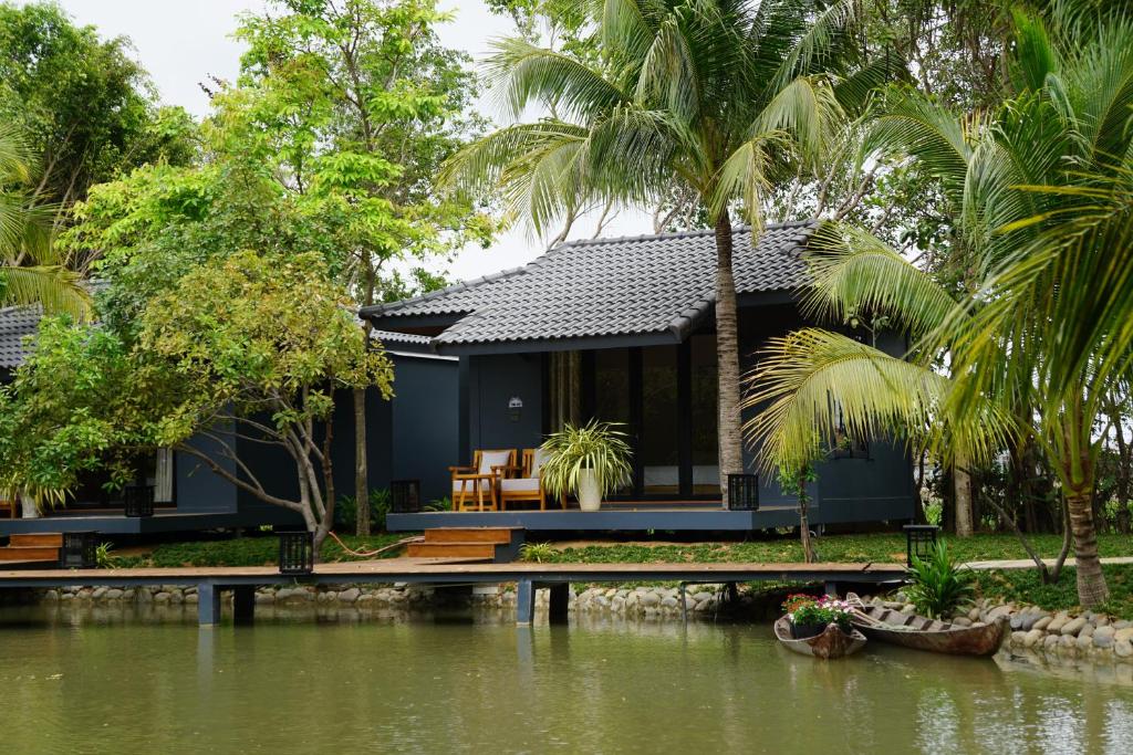 a house by the water with palm trees at Annhien home's in Phan Rang–Tháp Chàm