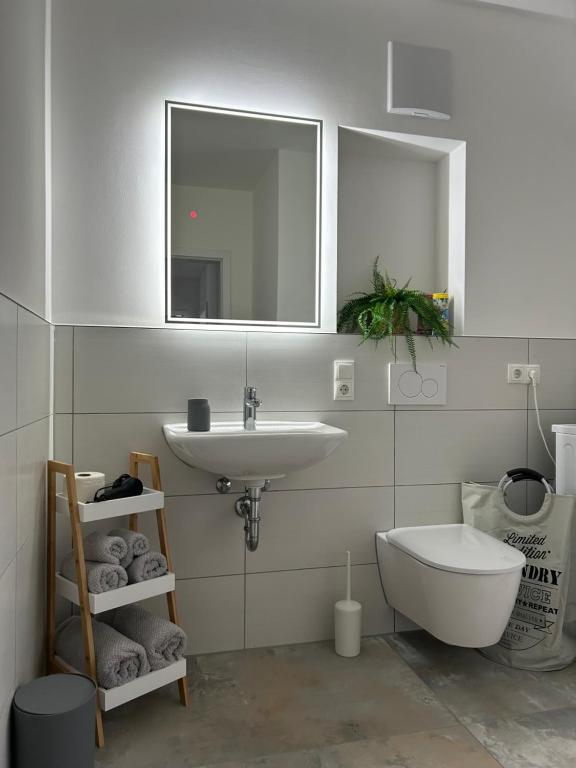 uma casa de banho com um lavatório, um WC e um espelho. em Elegantes 2 Zimmer Apartment Top Lage em Bruchsal
