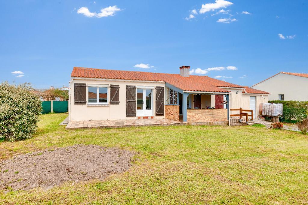 une petite maison blanche avec une cour dans l'établissement Évasion en famille à Brem-sur-Mer, à Brem-sur-Mer