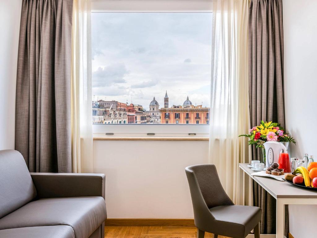 a room with a view of the city from a window at Mercure Roma Centro Termini in Rome