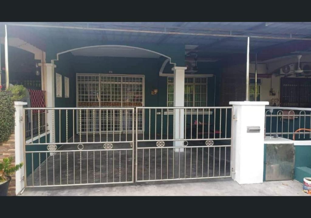 um portão em frente a uma casa em Jalinan Qaseh Homestay em Seri Manjung