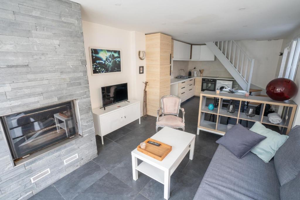 ein Wohnzimmer mit einem Kamin und einem Sofa in der Unterkunft Le Traditionnel - Maison avec Jardin & Parking - Idéal Disneyland & JO in Lagny