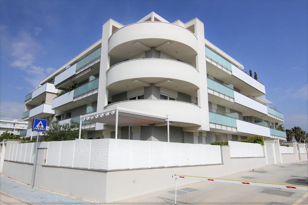 a white apartment building with a parking lot at Appartamento Raffaello in San Benedetto del Tronto