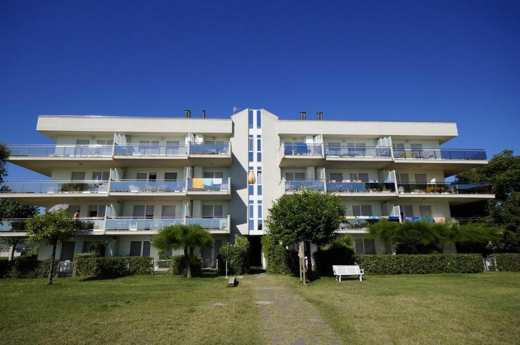 un grande edificio bianco con un parco di fronte di Residence Brezza Di Mare a San Benedetto del Tronto
