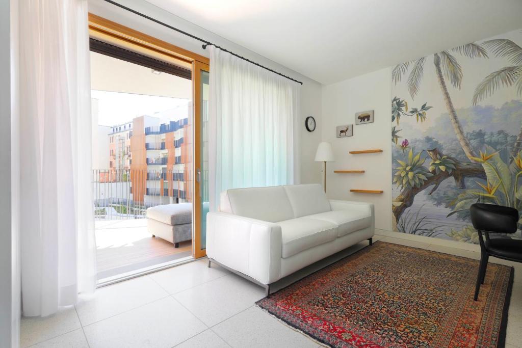 un soggiorno con divano bianco e finestra di Luxury Apartment con Terrazza, Palestra, CoWork & Box Privato a Milano