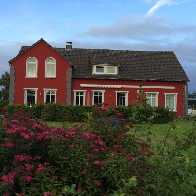 a red house with flowers in front of it at 3-Raum Ferienwohnung "Scheppler" in Rabel