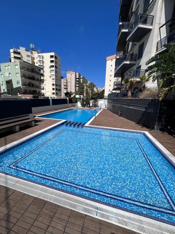 ein großer Pool in der Mitte eines Gebäudes in der Unterkunft BAHIA alquiler solo para familias in Playa de Gandia