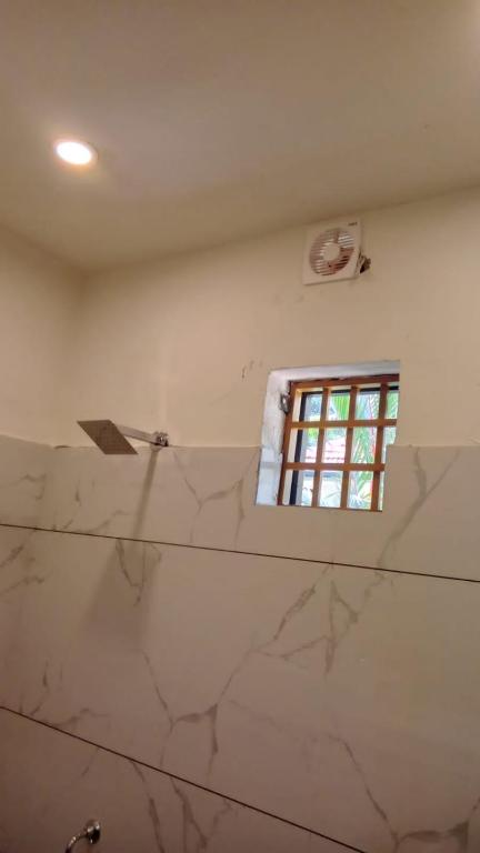 a bathroom with a window and a marble wall at TX property 11 in Gurgaon