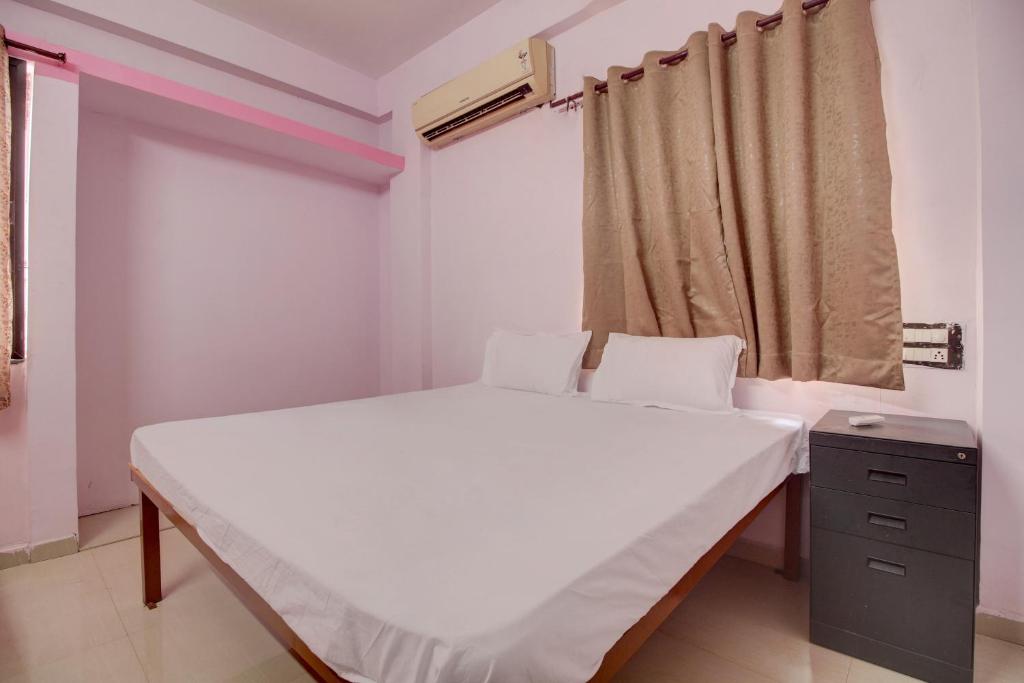 a small bedroom with a bed and a window at Super OYO Hotel Elite Inn in Korādih