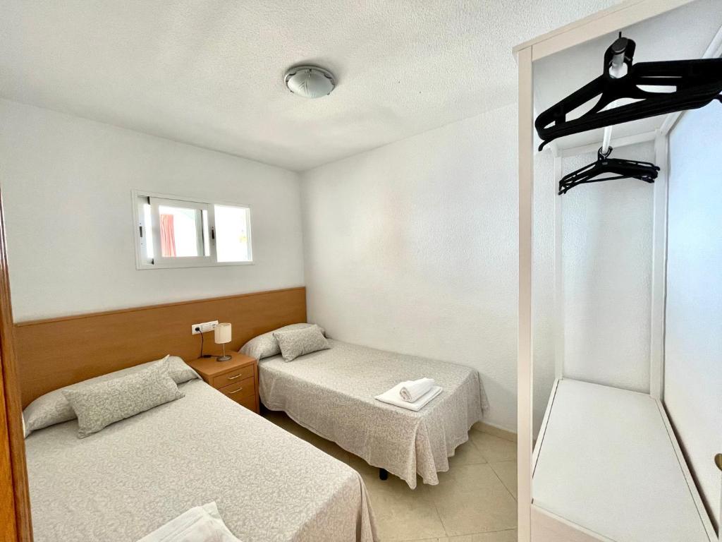 Habitación con 2 camas y espejo. en Las Damas - Aloturin Benidorm, en Benidorm