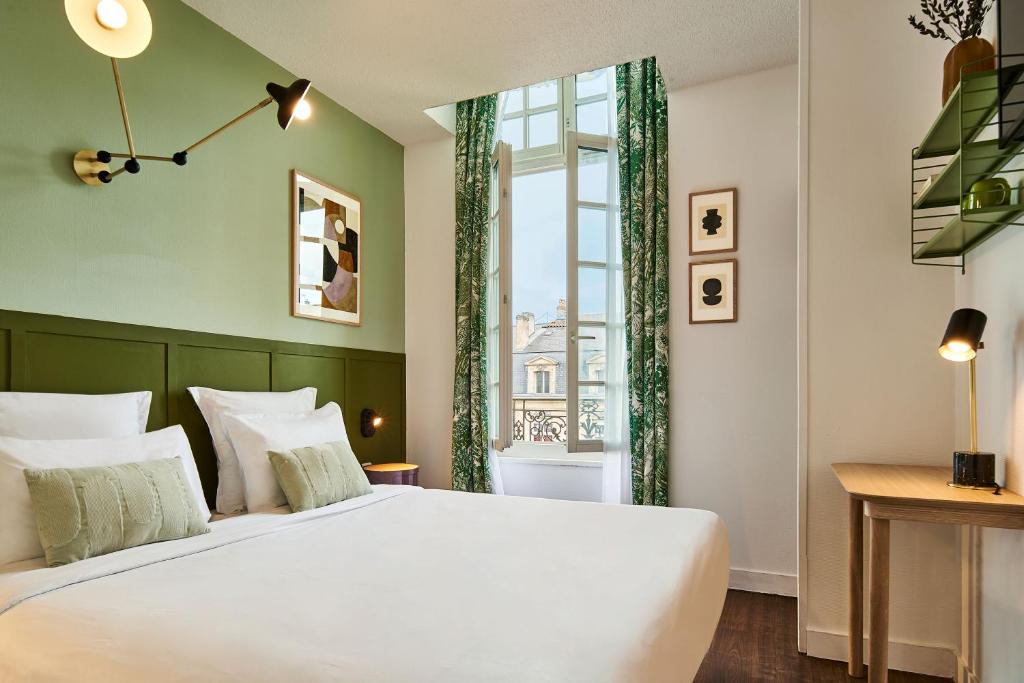 Un dormitorio con una cama grande y una ventana en Hôtel Bordeaux Clémenceau by Happyculture, en Burdeos